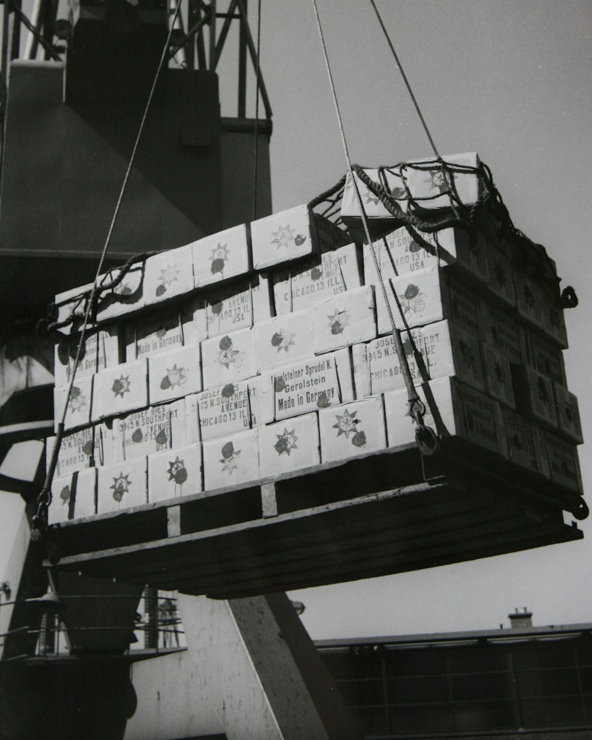 Black and white photograph of a Gerolsteiner shipment, to be transported via ship. 