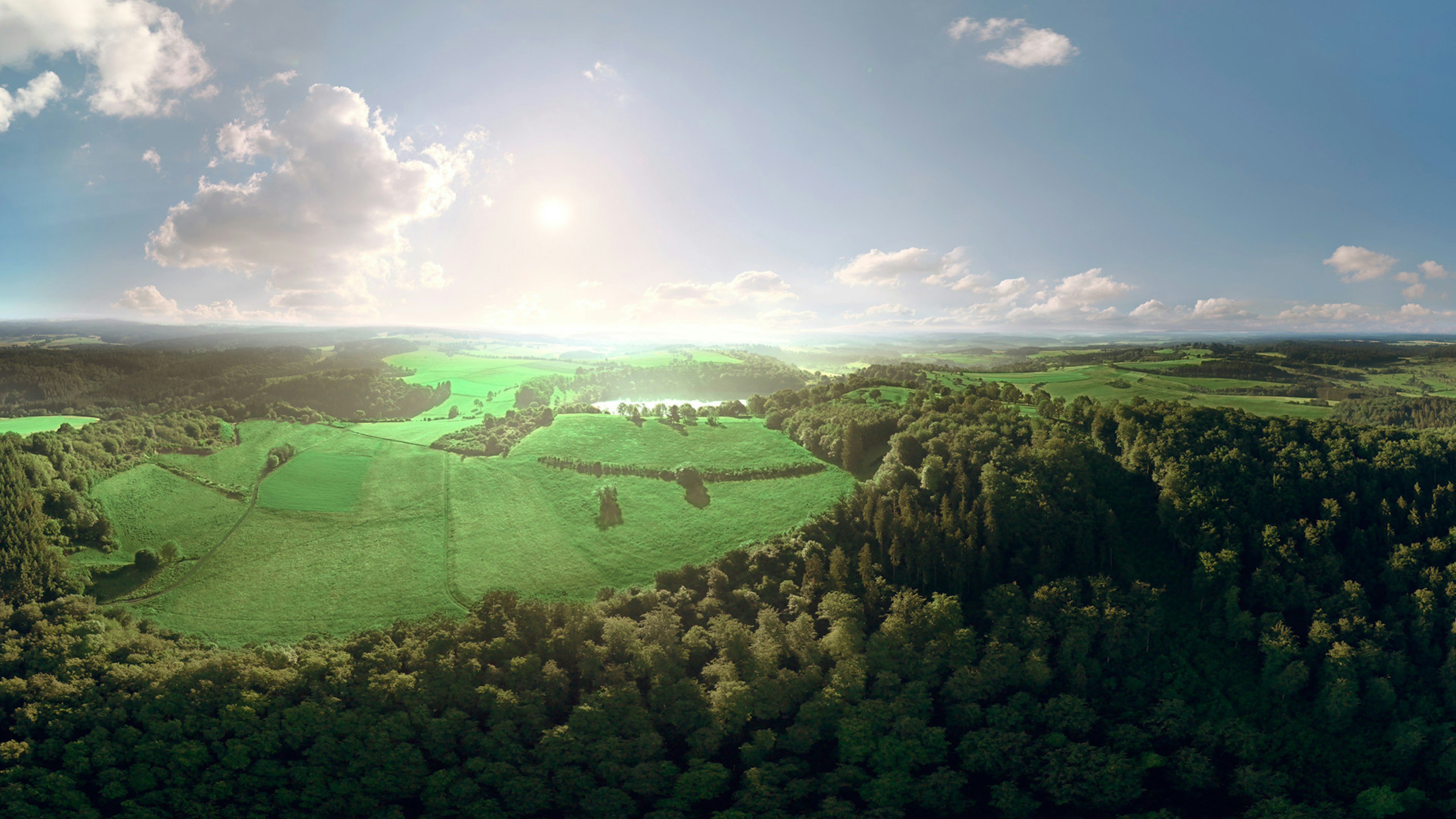 Eifel-Landschaft mit Wäldern und Wiesen von oben, auch ein Maar ist zu sehen